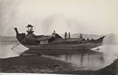 Zijaanzicht van een laung-zat- of rijstboot afgemeerd aan de oever van de Irrawaddy-rivier