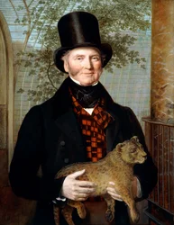 Portret van Edward Cross, halffiguur, in een zwarte jas en roodgeruite vest, met een leeuwenwelp in de hand