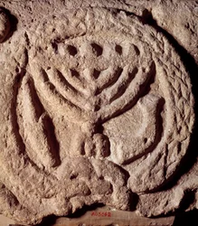 Jodendom: architectonisch element in basalt van een synagoge versierd met een kandelaar met zeven armen (Menora of Menorah), palm en trompet. Uit Transjordanië. Ongeveer 100 AD. Parijs, Louvre Museum