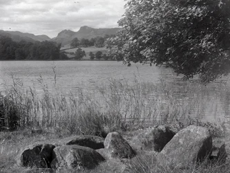 Uitzicht over Loughrigg Tarn, op de voorgrond enkele stenen in de grond