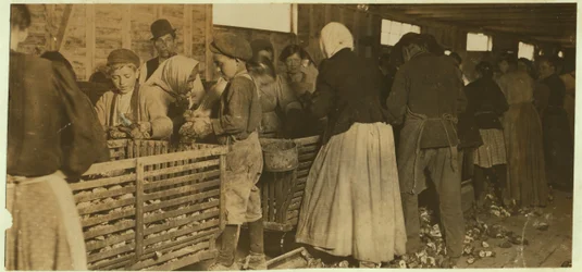 Johnnie, oesterschiller van 9 jaar, bekeken door de baas (met pijp) van de schilfabriek in Dunbar, Louisiana, 1911