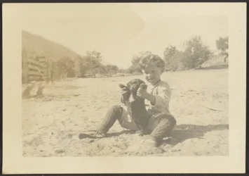 [Jongen en hond op het strand]