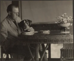 [Man en hond aan tafel]