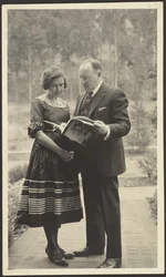 [Man en vrouw buiten staand met tijdschrift]