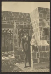 [Staande man met kind in huis in aanbouw].