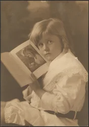 [Portret van een kind dat een boek openhoudt bij een soortgelijke illustratie]