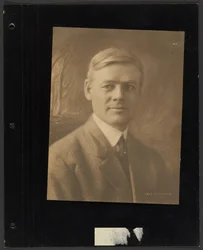 Portret van een zittende man voor een geschilderd decor