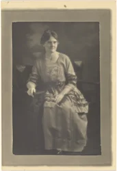 [Portret van een zittende vrouw in jurk met lintaccenten].
