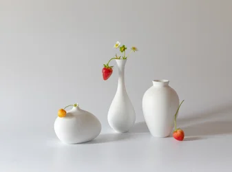 Aardbeien en witte vazen