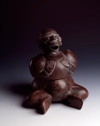 Precolumbiaanse kunst, Maya-beschaving, beginperiode: antropomorfe kleivaas die een man uitbeeldt die zijn handen op zijn borst legt en een apenmasker draagt met zijn mond open
