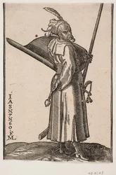 Staande soldaat (akinci), profiel naar rechts; in de rechterhand een strijdknots, in de linkerhand een lans waarvan de top buiten de bovenste kaderlijn is; op de linkerarm een schild met de binnenkant naar boven, aan de linkerzijde een zwaard