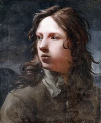 Een jonge man, buste lengte, in een grijs jasje