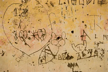 Graffiti gekrast in een oude buitenpleistermuur