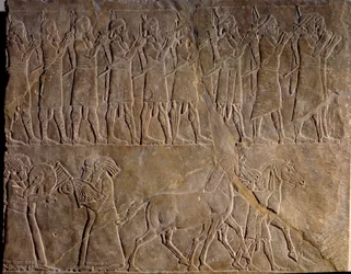 De muzikanten van het leger van Assurbanipal. Laag reliëf in kalksteen ca. 640 v.Chr. (Neo-Assyrische periode, ca. 1000-612 v.Chr.). Ontdekt in Nineveh, Mesopotamië. Louvre Museum