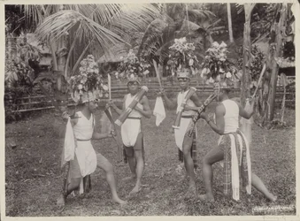 Indische jongens in kostuums dansen met krissen in de hand