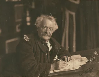 [Félix Nadar zit aan schrijftafel].