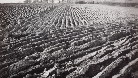Omgeploegd veld en hooibergen
