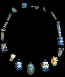 Ketting in glas pasta met hangers die bebaarde hoofden afbeelden, oorspronkelijk uit Olbia, nu bewaard in het Nationaal Archeologisch Museum van Cagliari