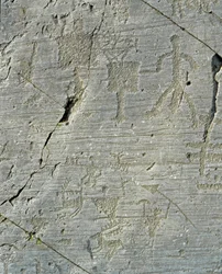 Prehistorie, beschaving van de Camunni, rotskunst: een grafrots met scènes van hertenjacht en het dagelijks leven in een dorp. Periode tussen het neolithicum en de bronstijd. Capo di Ponte, Parco nazionale delle incisioni rupestri di Naquane, Valcamonica