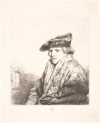 Jonge man met een fluwelen pet met boeken naast hem