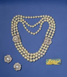 Selectie pareljuwelen: drierijige parelketting met diamanten clips; knopvormige oorbellen van gekweekte Zuidzeeparels; gouden en geëmailleerde broche van Lalique, ca. 1900