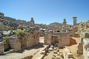 Uitzicht door de gewelfde ingang van het Xanthos-theater naar de orkestbak, met zuil en Harpy-tombe, Xanthos, Turkije