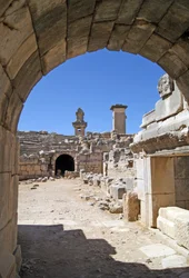 Uitzicht door de gewelfde ingang van het Xanthos-theater naar de orkestbak, met zuil en Harpy-tombe, Xanthos, Turkije (foto)