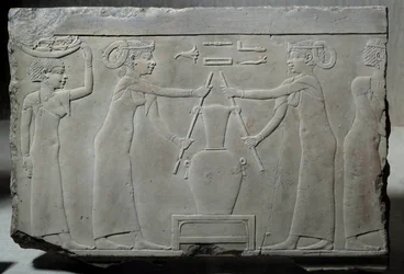Egyptische antiquiteit: laag kalkstenen reliëf dat vrouwen voorstelt die leliebloemen persen om de essentie genaamd 