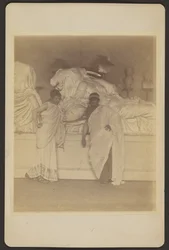 [Twee mannelijke studenten in Griekse kleding voor een gipsafgietsel van de drie lotgevallen van de Elgin Marbles].