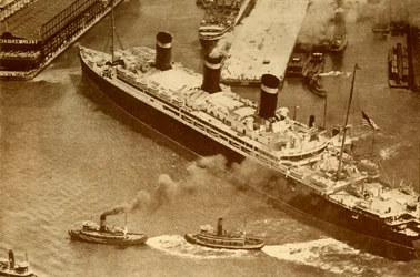 Een luchtfoto van de Leviathan die door kleine sleepboten naar haar dok in New York wordt gesleept, ca. 1930