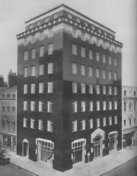 Een geheel zwart gebouw in Londen verlicht door een kraag van wit kant, ca. 1935