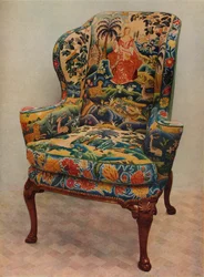 Een gestoffeerde fauteuil met vleugels, gesneden walnoothouten frame en originele zijden borduurwerk bekleding