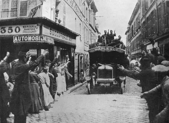 Britse troepen ontvangen een welkom bij aankomst per motorwagen in een Franse stad, 1915