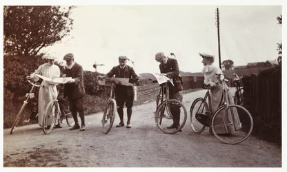 Fietsers die naar kaarten kijken, circa 1900