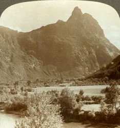 Scherpe pieken van Romdalshorn bekronen de bergwand boven de Rauma-rivier, Noorwegen, ca. 1905
