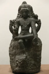 Het Victoria en Albert Museum. Shiva als Dakshinamurti. 1200-1300. Late Chola periode. Graniet. Zuid-India (Tamil Nadu). Verenigd Koninkrijk