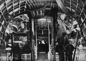 De middenkanonniers van een RAF-vliegboot alert op hun posten, c1940
