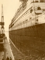 Zicht op stuurboordzijde van de Majestic toen ze de drijvende droogdok binnenkwam, ca. 1930