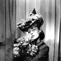 Vrouw met een hoed met een sluier, die een boeket bloemen vasthoudt, Parijs, 1943