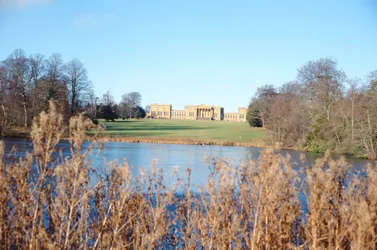 Uitzicht vanaf het meer op het huis, gebouwd door Sir John Vanbrugh en park aangelegd door Capability Brown