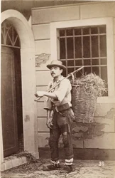 Kleine beroepen: portret van een stroverkoper met manden op de rug