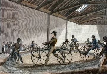 Interne weergave van de manege voor hobbelpaard. Man die fietsen bestuurt (fietsen zonder pedalen uitgevonden door Baron Karl Drais)