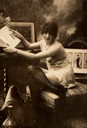 Portret van een jonge vrouw in intieme kleding, zittend aan een tafel met een boek