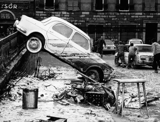 Een auto over een balustrade gegooid in de Via dei Renai tijdens de overstroming van Florence, november 1966 (z/w foto)