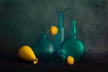 Blauwgroene flessen, gele bloemen