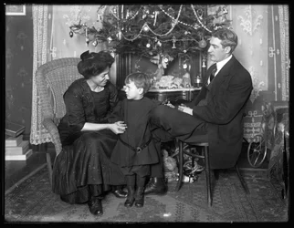Dan Seymour en familie in informele pose, zittend onder een kerstboom, Kerstmis 1912