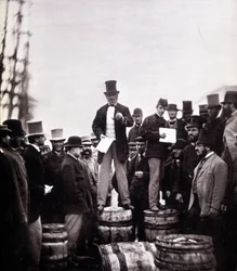 Scène van politieke redevoering op straat: de man staat op een vat en spreekt tot een uitsluitend mannelijk publiek. Foto door William Notman (1826-1891), Musee McCord Museum, Montreal. Eind 19e eeuw